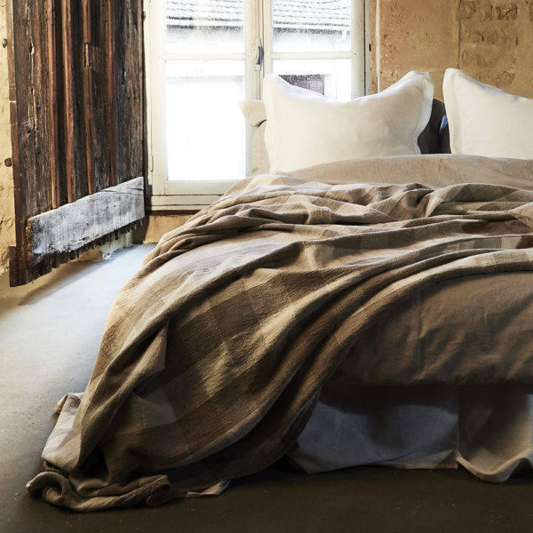 joli plaid en pur lin beige a carreaux blanc sur une parure de lit en lin naturel