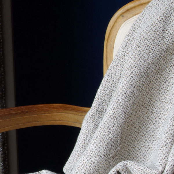 joli plaid en lin lavé couleur gris clair posé sur fauteuil