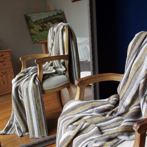 joli plaid en lin lavé couleur beige imprimé posé sur fauteuil