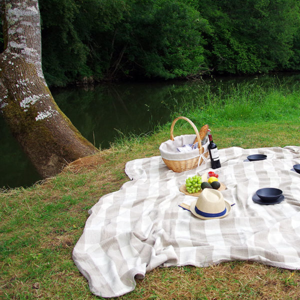 pique-nique repas pris en plein air dans un cadre champêtre et installé par terre avec plaid en pur lin lavé